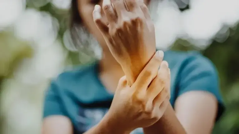 Karpaltunnelsyndrom Frau hält sich das Handgelenk vor Schmerzen